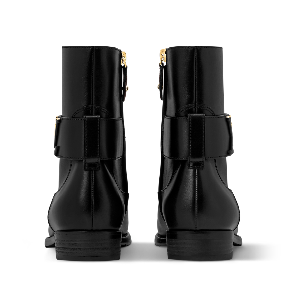Louis Vuitton Midtown Flat Ankle Boot in black supple calf leather with decorative belt strap and LV Initials accessory.