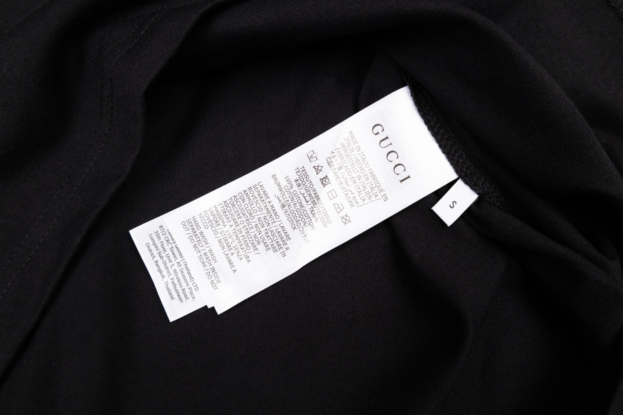 Model wearing the Gucci T-Shirt Without Collar 'Black' styled with jeans and a jacket, perfect for casual outings.