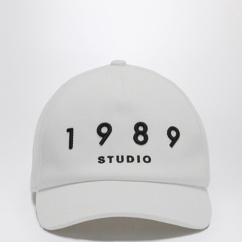 White cotton cap with black '1989 Studio' embroidery, minimalist streetwear accessory